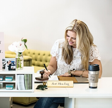 Receptionist with name tag, desk plate and travel mug