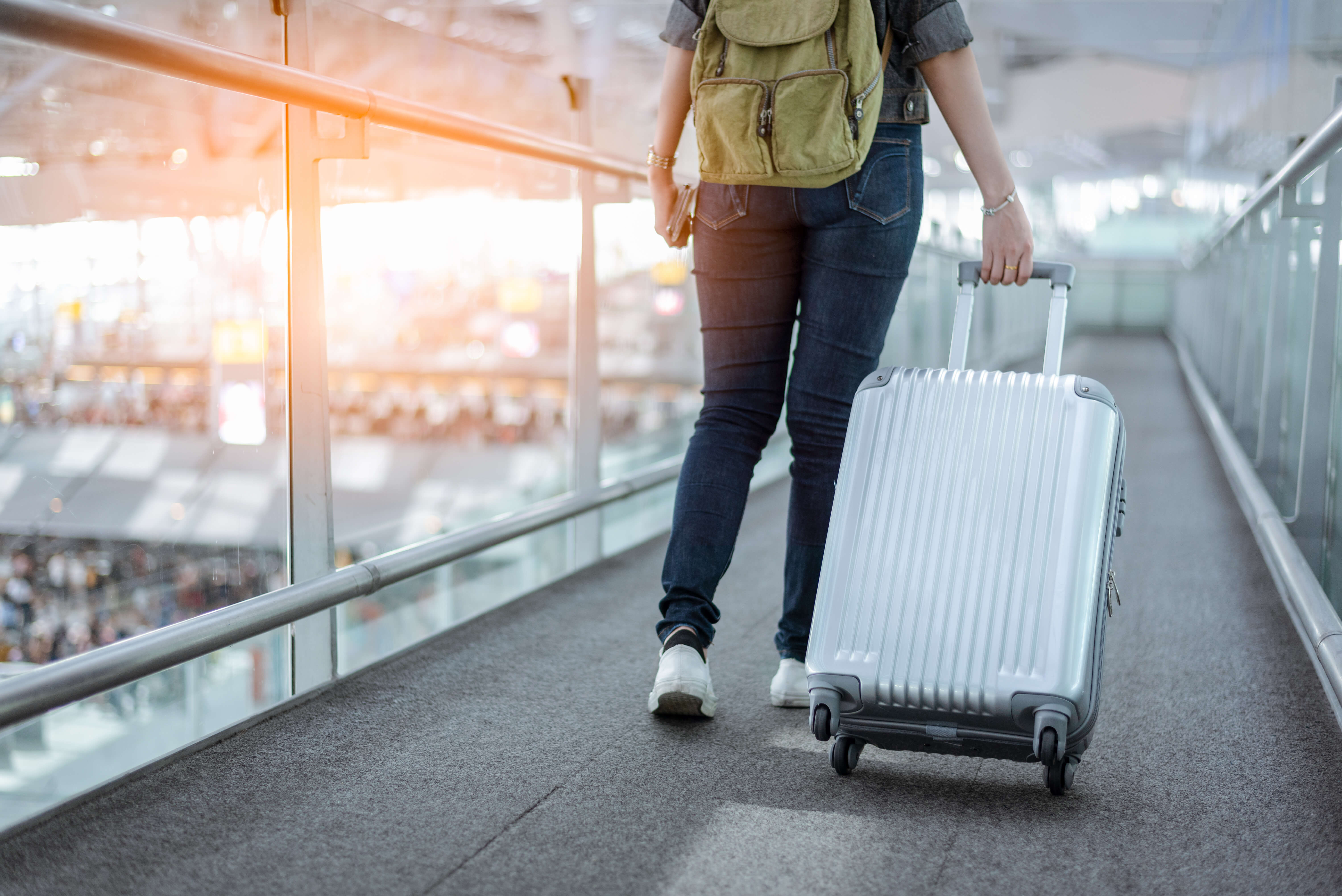 Woman Traveling with a Suitcase in an Airport Terminal