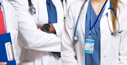 Medical Professionals Standing Next to Each Other With White Coats